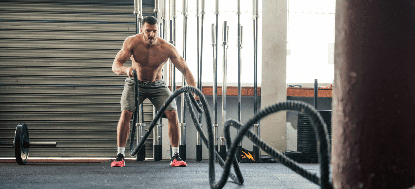 man working out on ropes at the gym